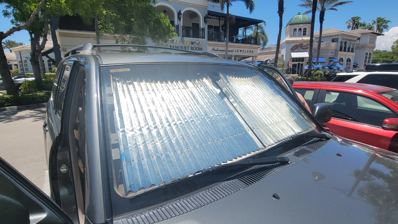 protective car sunshades under windshield of parked car on a holiday rush