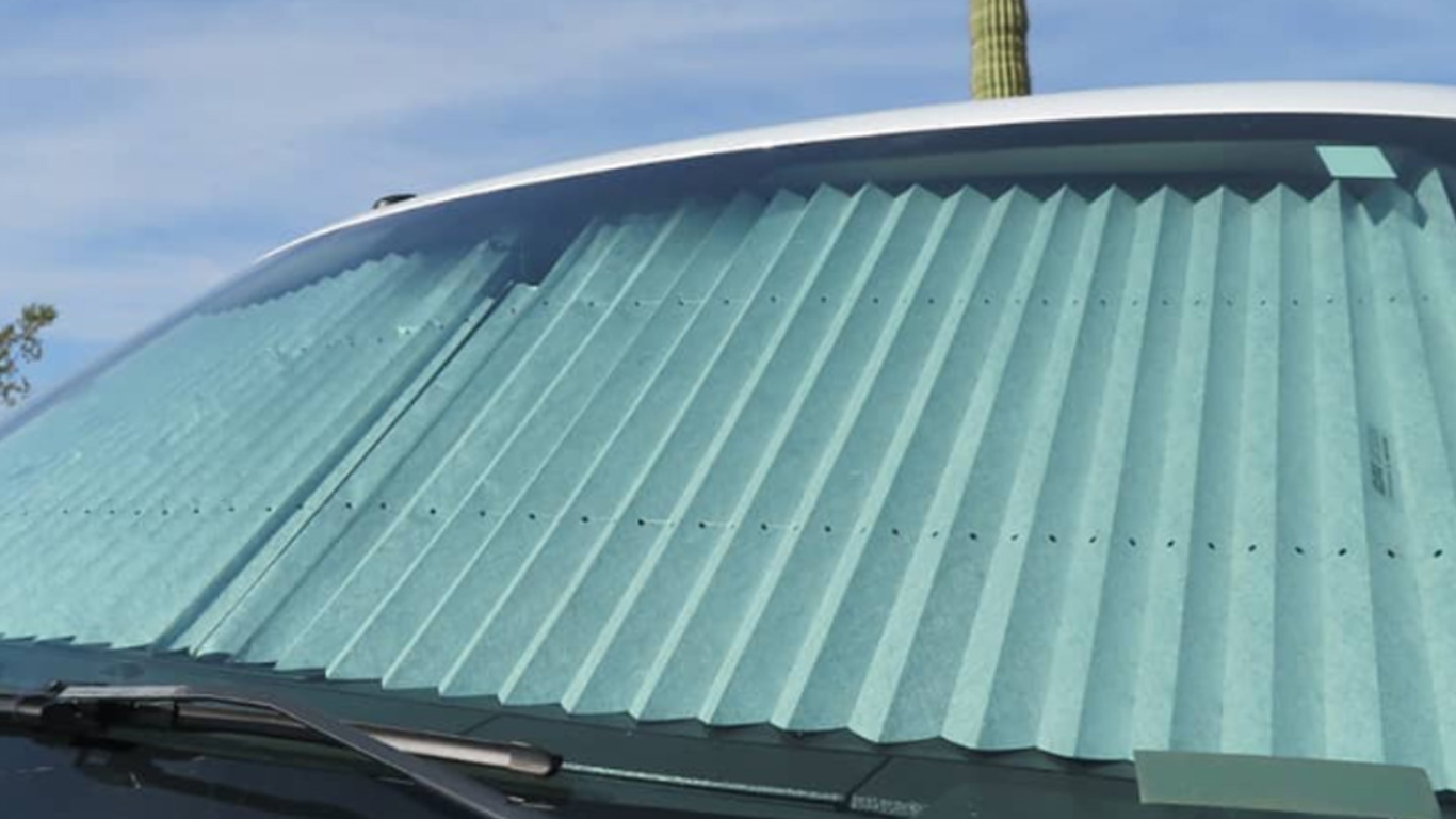 Windshield covered with a folded new car sunshade for UV protection.